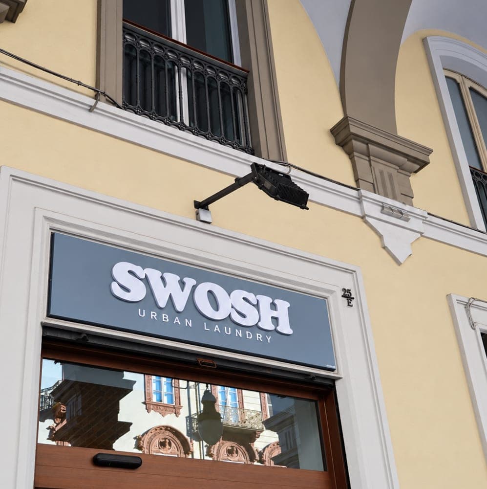 L'insegna SWOSH sopra l'ingresso di Via Cernaia 25/E, sotto i portici