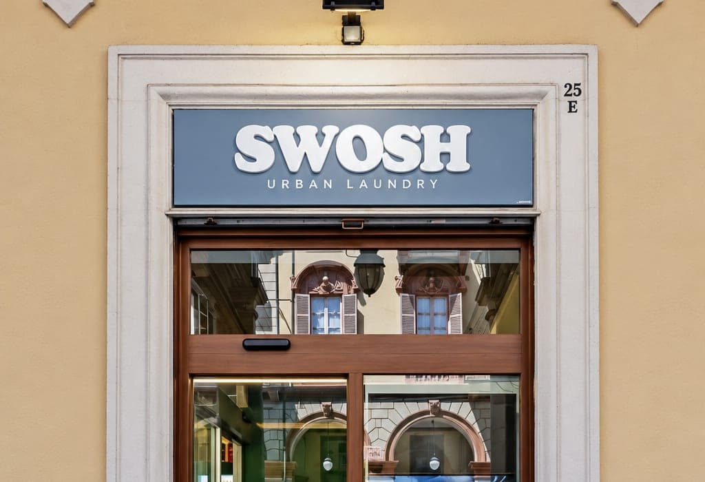 L'ingresso di SWOSH al civico 25/E di Via Cernaia, con l'insegna sopra la porta scorrevole