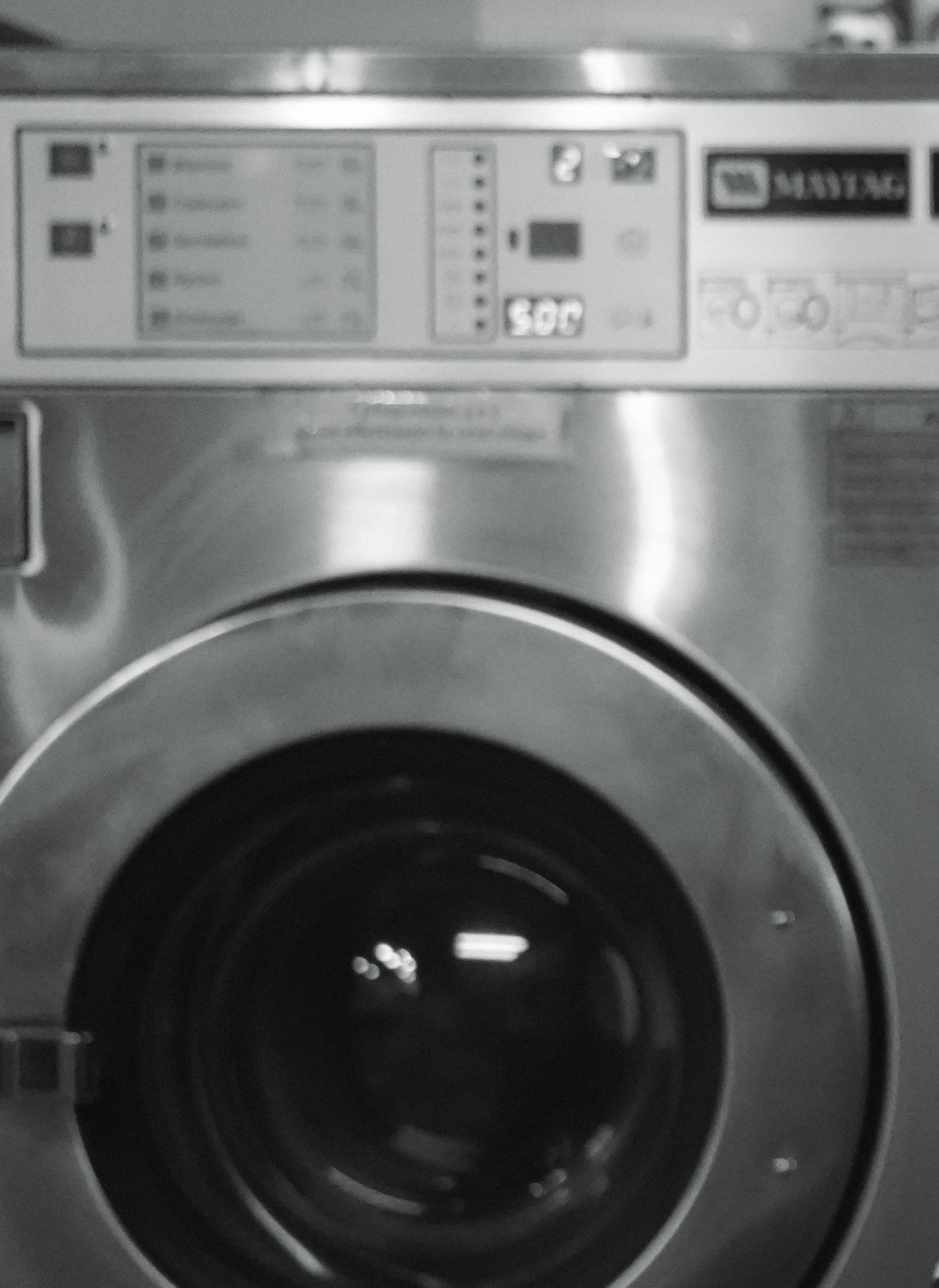 L'oblò di una lavatrice Maytag nel negozio di Via Cernaia, in bianco e nero