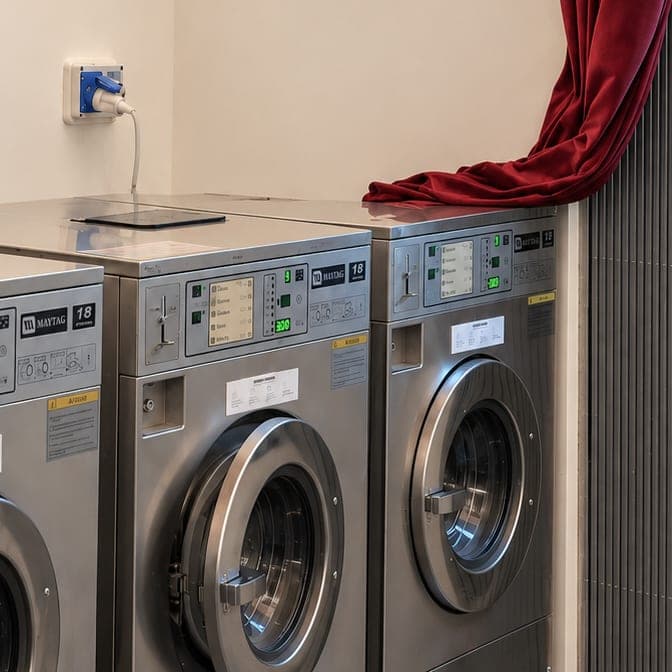 Due lavatrici Maytag da 18 libbre in fila, accanto alla tenda burgundy
