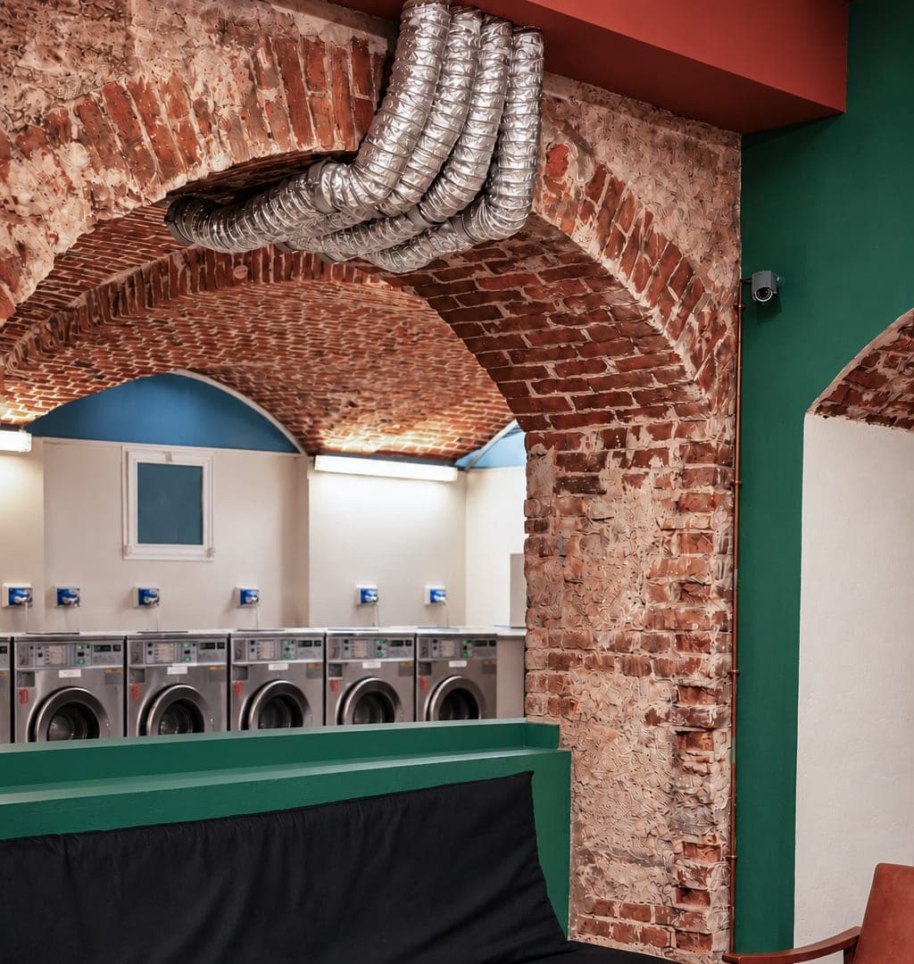 The lounge sofa and, through the brick arch, the row of washers